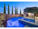 Resort-style pool with waterfall, spa, and fire bowls, perfect for relaxation and entertaining at 12219 Crystal Shore Ave, Las Vegas, NV 89138
