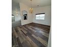 Bright dining room featuring wood floors, a chandelier, and an arched doorway at 1830 Justine Ct, Pahrump, NV 89048