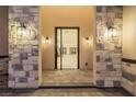 Elegant entryway featuring stone pillars, modern lighting, and a glimpse into the home's contemporary interior at 19 Rue Grimaldi Way, Henderson, NV 89011
