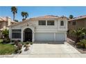 Two-story home featuring desert landscaping, a tile roof, an arched entry gate, and a two-car garage at 222 Hollyfern St, Henderson, NV 89074