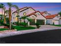 A white stucco two-story home with a red tile roof, attached garage, and well-manicured landscaping at 2589 Sun Reef Rd, Las Vegas, NV 89128