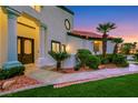 A covered front entry features decorative columns and manicured shrubs and landscaping at 2589 Sun Reef Rd, Las Vegas, NV 89128