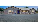 Single-story home featuring desert landscaping, light stucco, and blue front door at 2650 Sagebrush Ave, Pahrump, NV 89048