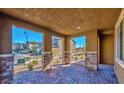 Cozy covered patio with stone pillars and brick flooring, perfect for outdoor relaxation at 2887 Starling Summit St, Henderson, NV 89044