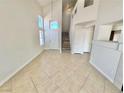Bright living room showcasing tile flooring, a staircase, and a front door at 3919 Lilac Haze St, Las Vegas, NV 89147