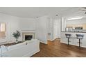 Open-concept living room featuring wood flooring, a fireplace, and bar seating to the kitchen at 5250 S Rainbow Blvd # 2070, Las Vegas, NV 89118