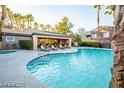 Resort-style pool area with a hot tub, palm trees, lounge chairs, and a shaded seating area at 5250 S Rainbow Blvd # 2070, Las Vegas, NV 89118