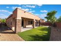 Charming backyard featuring a covered patio, artificial turf, and decorative gravel at 5384 Candlespice Way, Las Vegas, NV 89135