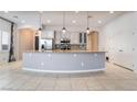 Open kitchen features modern appliances, stylish backsplash, and a large center island with pendant lighting at 5384 Candlespice Way, Las Vegas, NV 89135