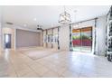 Bright living room features tile flooring, neutral walls, and sliding glass doors leading to the backyard at 5384 Candlespice Way, Las Vegas, NV 89135