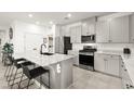 Modern kitchen features white cabinets, stainless steel appliances, and a large island with seating at 5530 Hill Spire St, Las Vegas, NV 89166