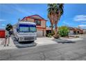 Two-story home with RV parked out front on driveway near palm trees at 5731 Fonchester Ct, Las Vegas, NV 89110