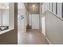 Bright foyer with tiled floors, staircase, and a view into the dining area at 5769 Larkdale St, Las Vegas, NV 89120