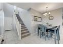 Inviting dining area with tiled floors, gray walls, modern chandelier and carpeted stairs at 6276 Point Isabel Way, Las Vegas, NV 89122