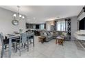 Open concept dining and living area with tiled floors, gray sofa, and contemporary decor at 6276 Point Isabel Way, Las Vegas, NV 89122