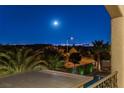 Night view of the city skyline from a balcony, showcasing lush landscaping and a tranquil pool below at 724 Step Beach St, Las Vegas, NV 89138