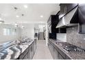 Open concept kitchen with sleek cabinetry, stainless steel appliances, large island, and seamless flow to staircase at 724 Step Beach St, Las Vegas, NV 89138