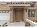 Inviting front entrance with a double door, stylish sconce lighting, and a well-manicured flower bed at 8216 Brittany Harbor Dr, Las Vegas, NV 89128