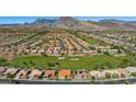 Stunning aerial view of the community nestled against a mountain range, featuring a golf course at 9409 January Dr, Las Vegas, NV 89134
