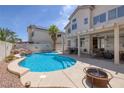 Inviting pool with rock features, a tanning ledge, and covered patio, perfect for outdoor entertaining at 9516 Belgate Ct, Las Vegas, NV 89129