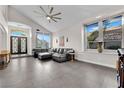Bright living room showcasing a comfortable sectional sofa, tile flooring, and large windows offering abundant natural light at 9705 Cameo Rose Ln, Las Vegas, NV 89134