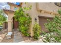 Inviting home featuring a covered front entryway, two-car garage, and a well-manicured lawn at 10294 Running Falls St, Las Vegas, NV 89178