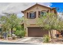 Two-story home featuring a well-maintained lawn, landscaping, and a two car garage at 10294 Running Falls St, Las Vegas, NV 89178