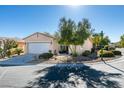 Single story home with a two-car garage and low maintenance desert landscaping in front at 10389 Felice Ave, Las Vegas, NV 89135
