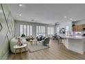 Bright living room area featuring hardwood floors, three large windows, and modern decor at 10389 Felice Ave, Las Vegas, NV 89135
