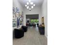 Inviting hallway with striking chandelier, tiled floors, and curated art collection at 11318 San Arezzo Pl, Las Vegas, NV 89141