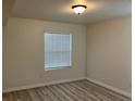 Cozy bedroom featuring wood-look flooring and a window with bright natural light at 1150 N Buffalo Dr # 2093, Las Vegas, NV 89128