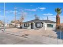Charming single story home with a gravel yard and palm tree in the front at 1401 E Clark Ave, Las Vegas, NV 89101