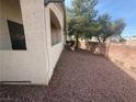 Low-maintenance side yard with desert rock landscaping and mature trees provides a private outdoor space at 1881 W Alexander Rd # 1035, North Las Vegas, NV 89032