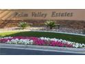 Welcome to Palm Valley Estates, with its stone wall, colorful flowers, and lush green landscaping at 217 Windsong Dr, Henderson, NV 89074