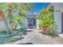 Landscaped front yard with lush green grass, mature trees, and a custom iron gate at 217 Windsong Dr, Henderson, NV 89074