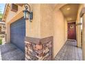 Close up on the stone accents and door to the two-car garage with brick paver driveway at 2293 Sky Island Dr, Henderson, NV 89002