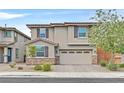 Charming two-story home featuring a neutral stucco exterior, a two-car garage and meticulously kept landscaping at 2486 Dragon Fire Ln, Henderson, NV 89052