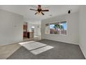 Bright living room with plush carpet, ceiling fan, and large window showcasing backyard at 2749 Invermark St, Henderson, NV 89044