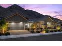 Beautiful home exterior featuring desert landscaping, two-car garage, and mountain views at 3131 Reverence Heights Ln, Las Vegas, NV 89138