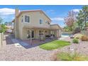 The backyard features a covered patio, green turf, and access to the inviting pool area; ideal for entertaining at 349 Clayton St, Henderson, NV 89074