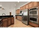 Modern kitchen with stainless steel appliances, wooden cabinets, and tiled backsplash at 653 Paloma Cir, Mesquite, NV 89027