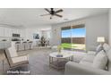 Bright open-concept living room featuring modern furnishings, neutral tones, and sliding glass doors to the backyard at 6854 Chargehand Ave, Las Vegas, NV 89156