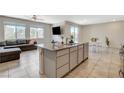Open concept kitchen with granite island, stainless steel appliances and tile flooring adjoining the living area at 7246 Dazzle Point St, North Las Vegas, NV 89084
