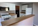 Galley kitchen boasts white cabinets and a breakfast bar at 8250 N Grand Canyon Dr # 2029, Las Vegas, NV 89166
