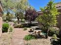 Lovely outdoor area with a patio table and lush greenery creates a peaceful retreat at 8777 Beckett Ridge Ave, Las Vegas, NV 89149