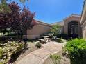 Charming entrance with a stone walkway leading to the front door surrounded by mature trees at 8777 Beckett Ridge Ave, Las Vegas, NV 89149