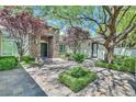 Green trees and other foliage enhance the curb appeal of this courtyard-style home at 9500 Balatta Canyon Ct, Las Vegas, NV 89144