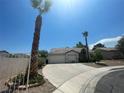 Single-story home with low maintenance desert landscaping, mature palm trees, and driveway leading to the garage at 1785 Puerto Way, Henderson, NV 89012