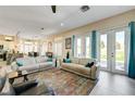 Bright living room featuring tile floors, neutral walls, comfortable sofas, and direct access to the backyard at 2625 Youngdale Dr, Las Vegas, NV 89134