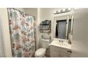 Cozy bathroom featuring a shower-tub combination, vanity, decorative mirror, and seashell decor at 2722 Sweet Basil Dr, Las Vegas, NV 89142